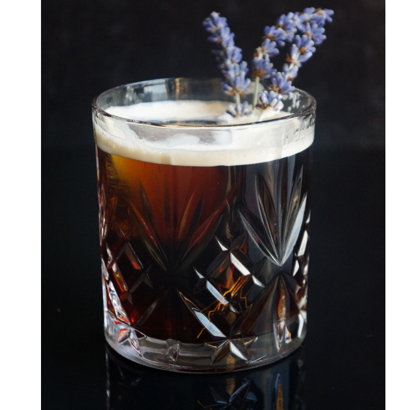 Gin and tonic cold brew cocktail with lavender garnish